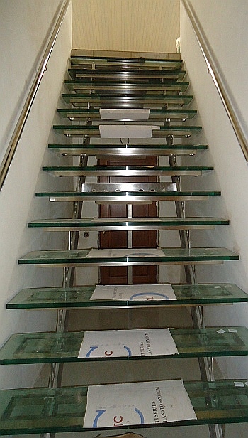 Стеклянная лестница на косоурах из нержавеющей стали в Москве